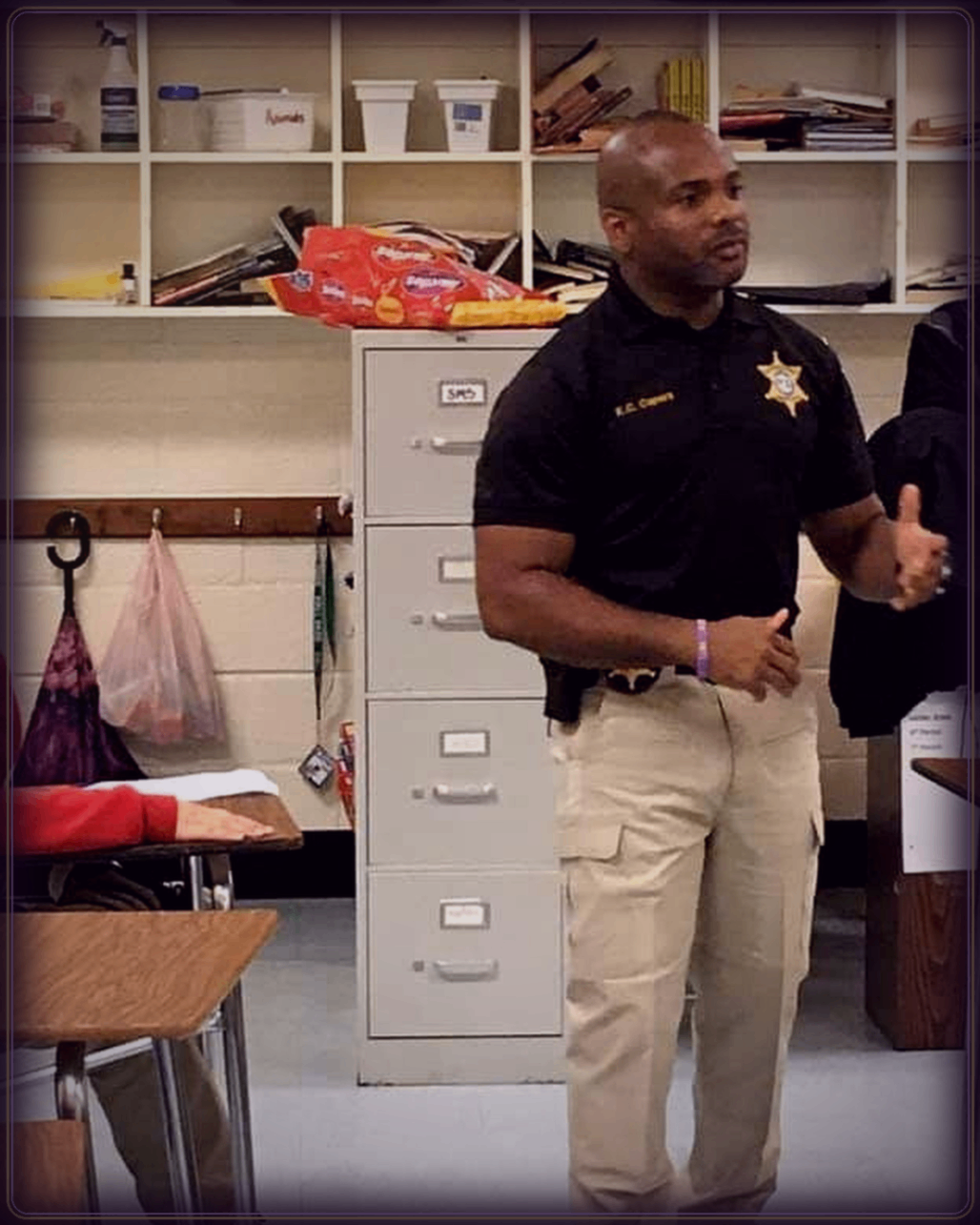 KC Capers in law enforcement uniform speaking to community